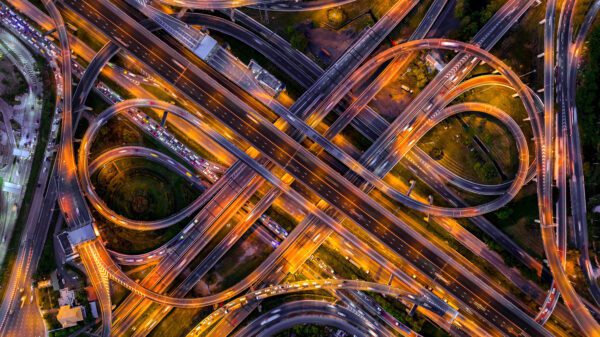 Aerial view of traffic on massive highway intersection at night.