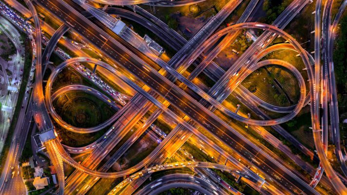 Aerial view of traffic on massive highway intersection at night.